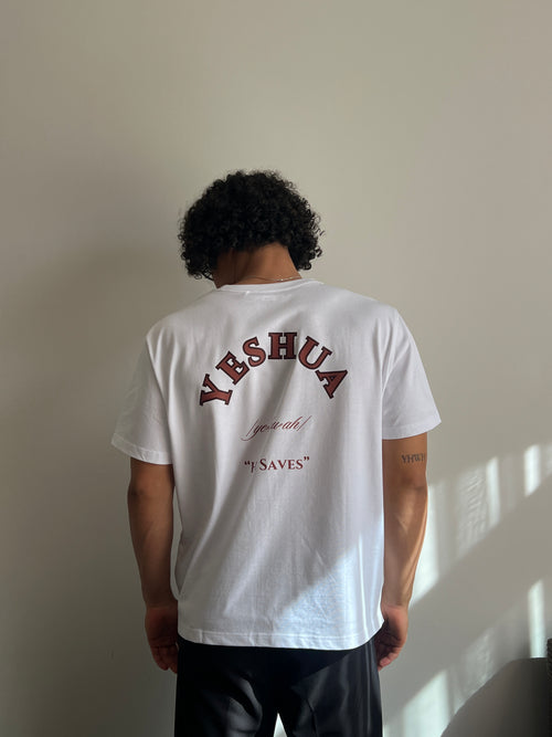 Person wearing a white t-shirt with brown text in an indoor setting