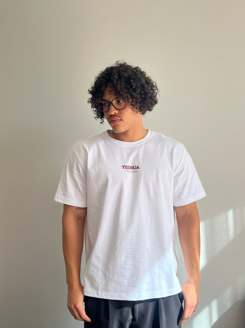 Person wearing a white t-shirt with a logo on a plain background